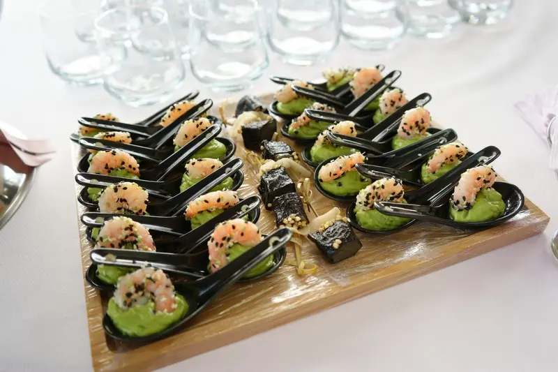 Amuse-bouches joliment présentés sur une petite planche en bois.